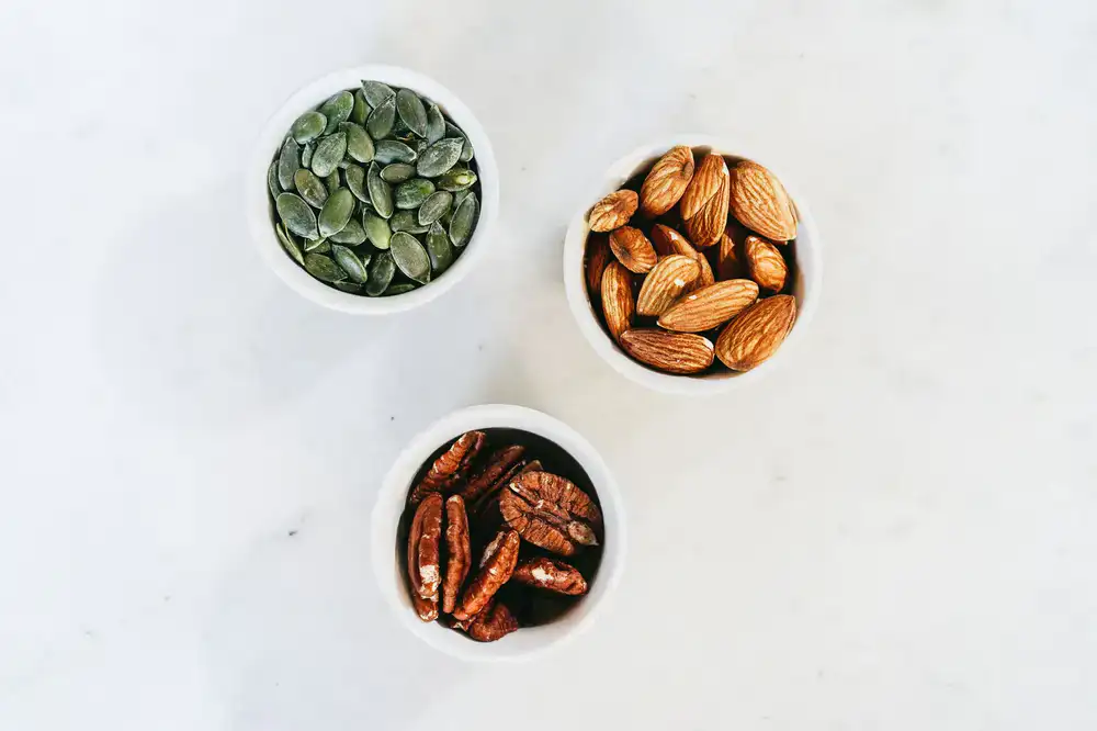 Bowls of almonds, walnuts, and pumpkin seeds